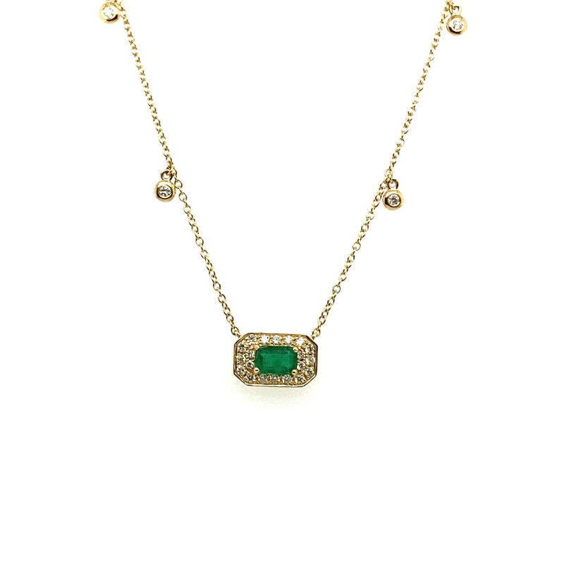 a gold necklace with a green stone and diamonds