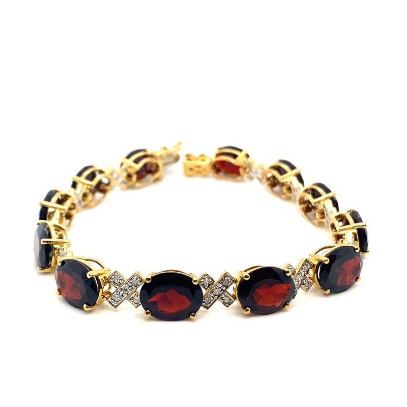 a gold bracelet with red and white stones