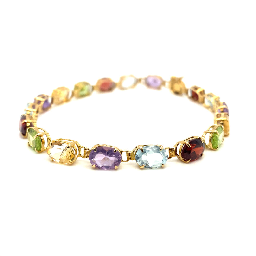 a gold bracelet with multi colored stones