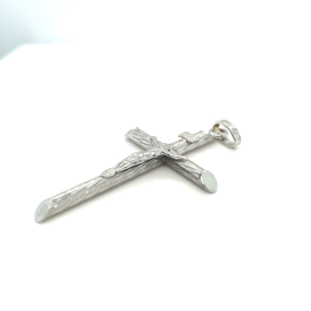 a silver cross is on a white surface