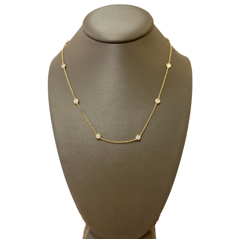 a necklace on a mannequin with gold beads