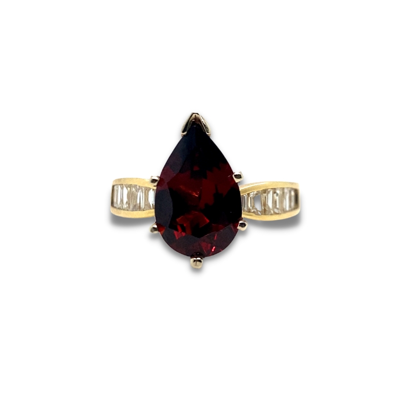 a ring with a red stone and two white diamonds