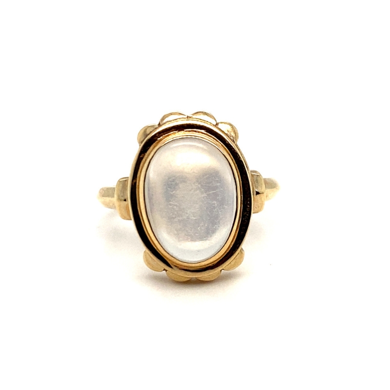 a gold ring with a white stone in it