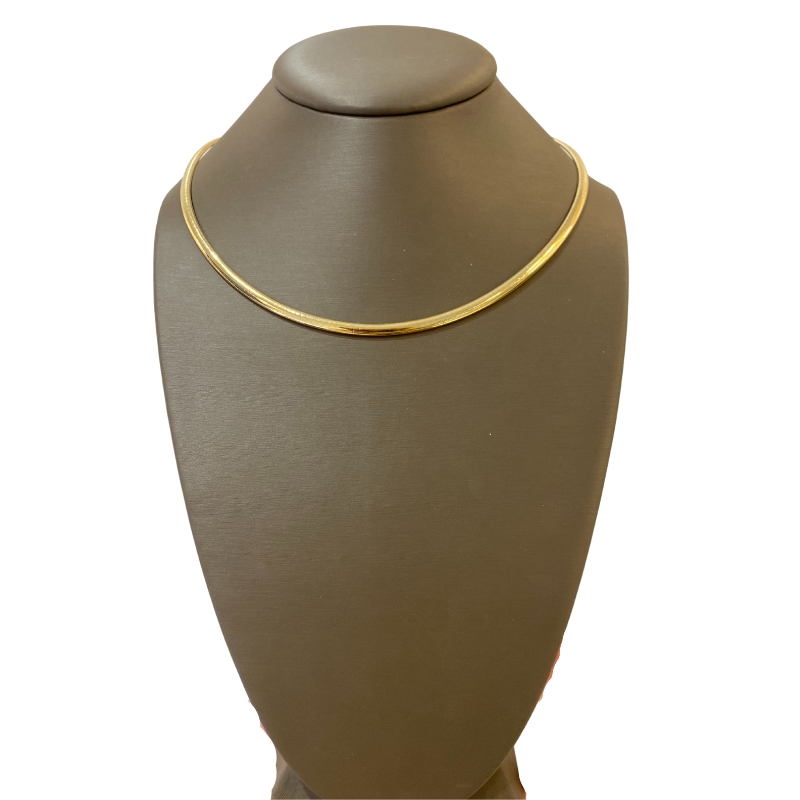 a gold necklace on a mannequin with a white background