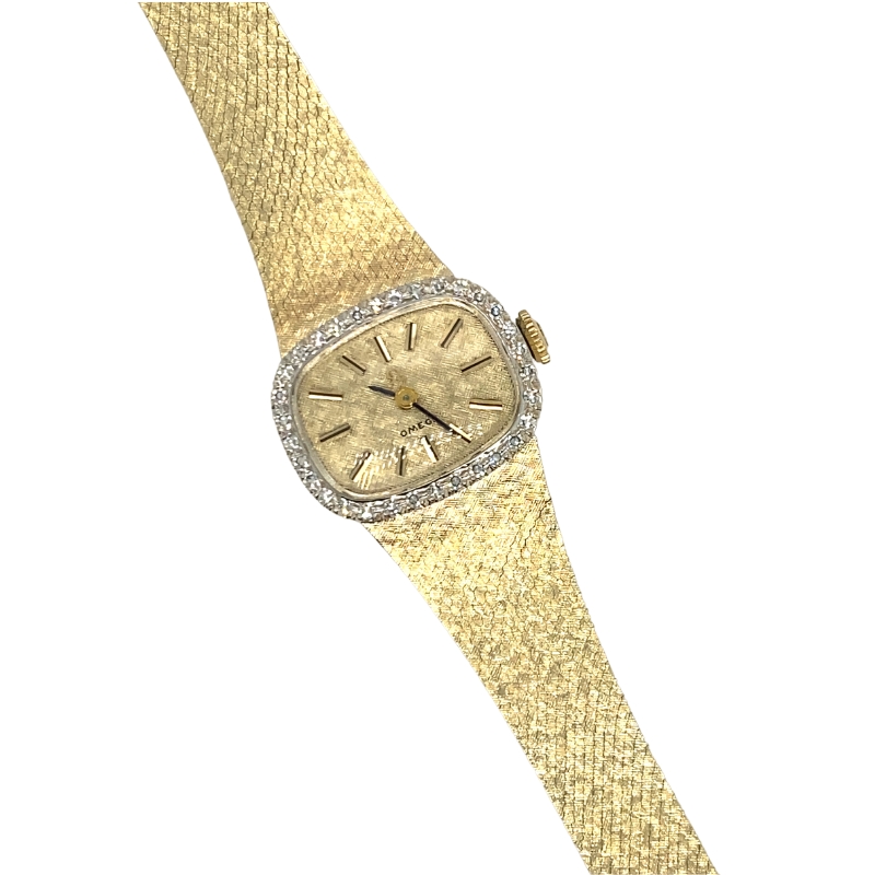 an old watch with diamond bezels on a gold mesh strap