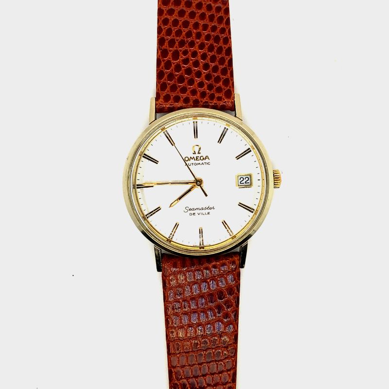 a watch with a gold case and white dial