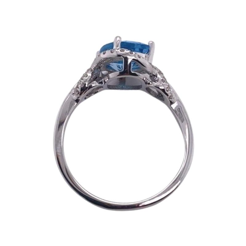 a blue topazte and diamond ring on a white background