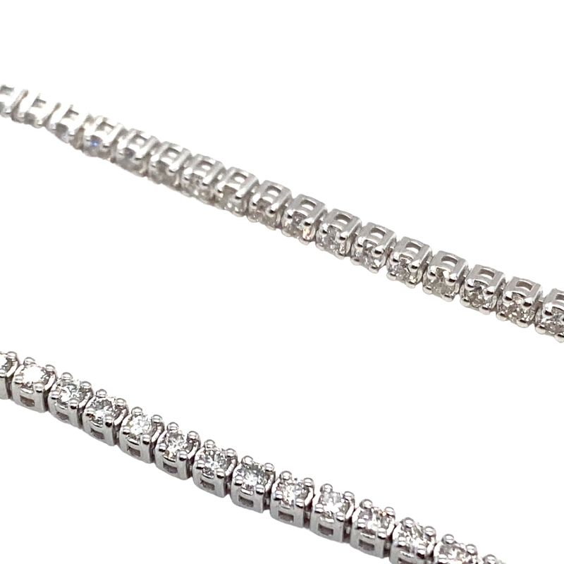 a pair of diamond tennis bracelets on a white background