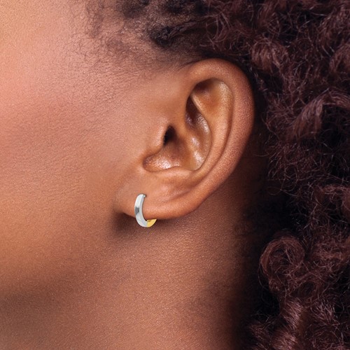 a woman with curly hair wearing a pair of earrings