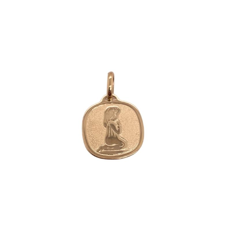 a small gold charm with a woman's head on it