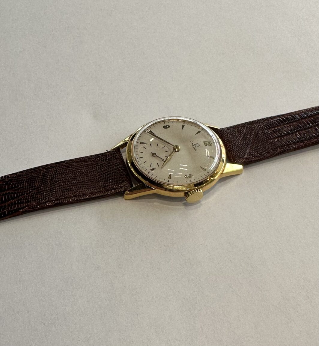 a watch sitting on top of a brown strap