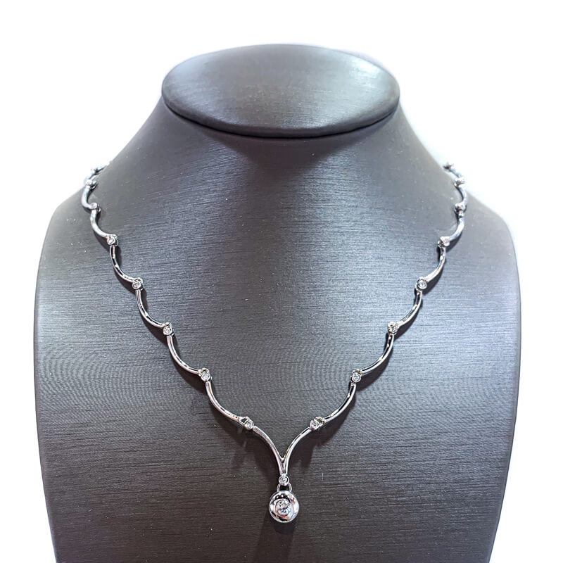 a silver necklace with a diamond on it