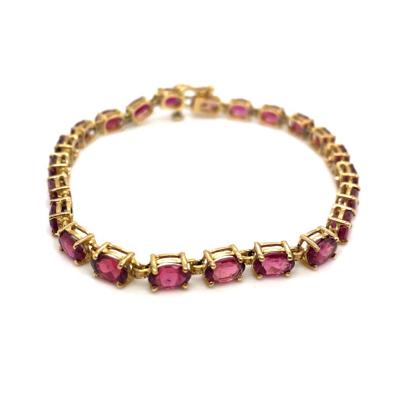 a gold bracelet with pink stones