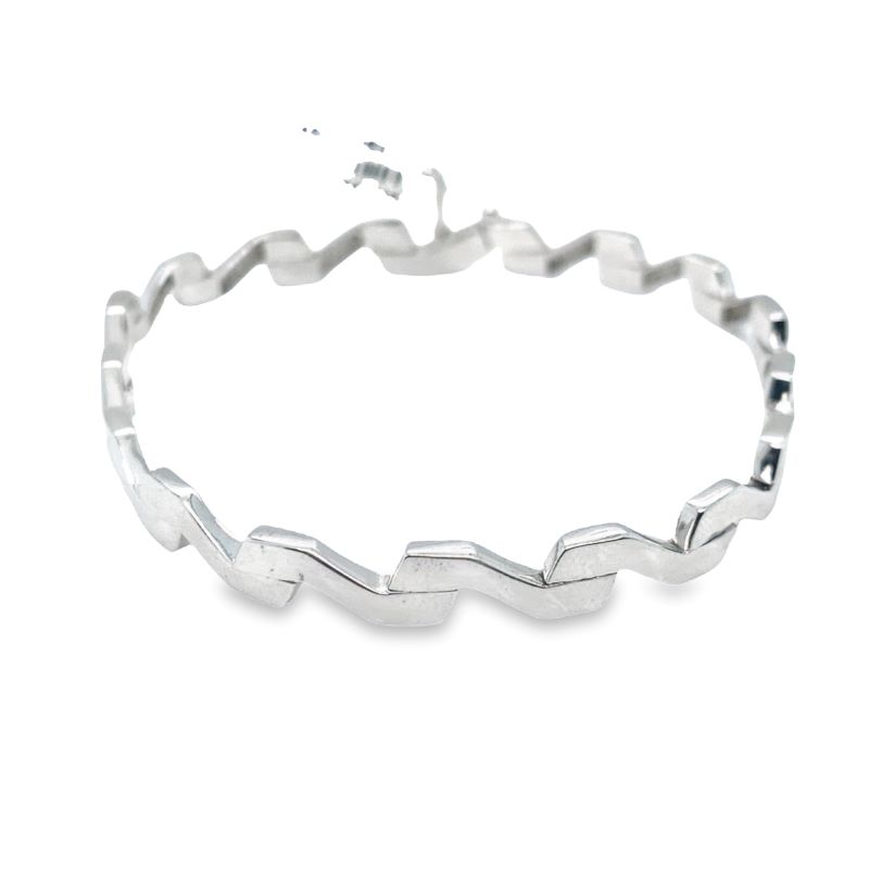 a silver bracelet with wavy lines on it