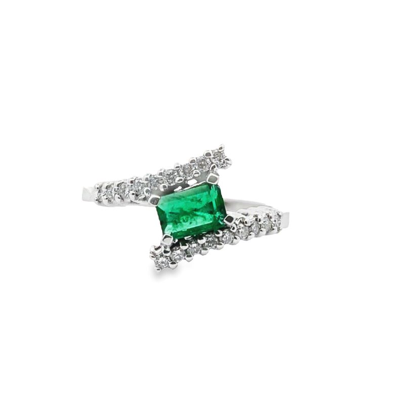 an emerald and diamond ring on a white background
