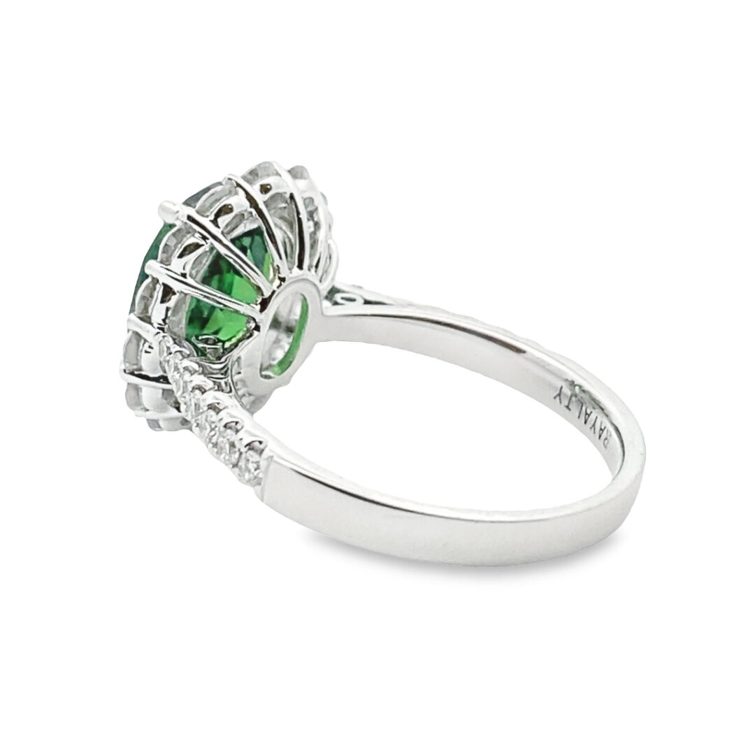 a ring with an oval green stone surrounded by diamonds