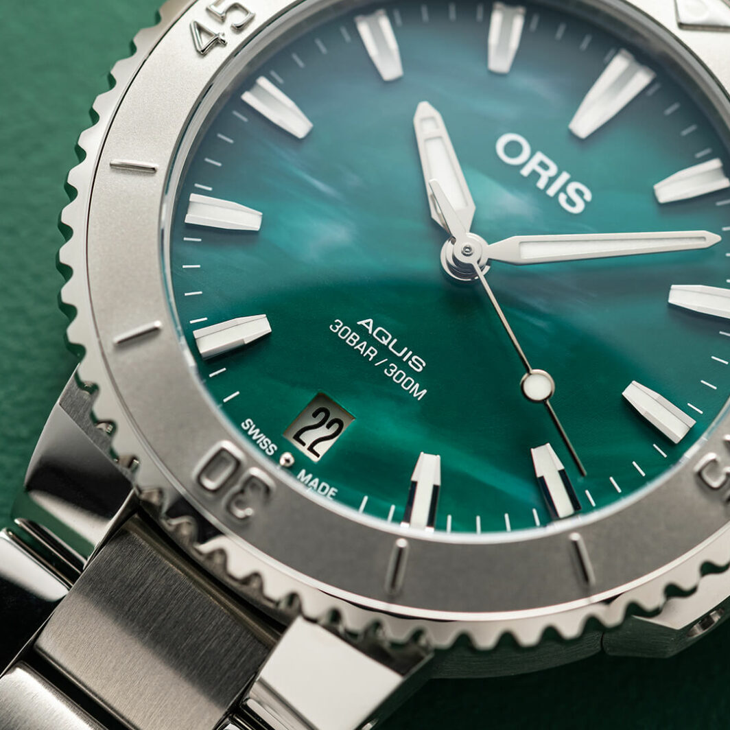 a close up of a watch on a green surface