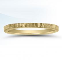 a yellow gold wedding ring with textured edges