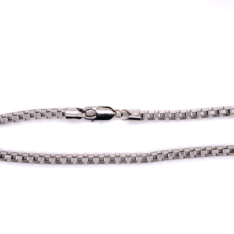 a close up of a silver chain on a white background