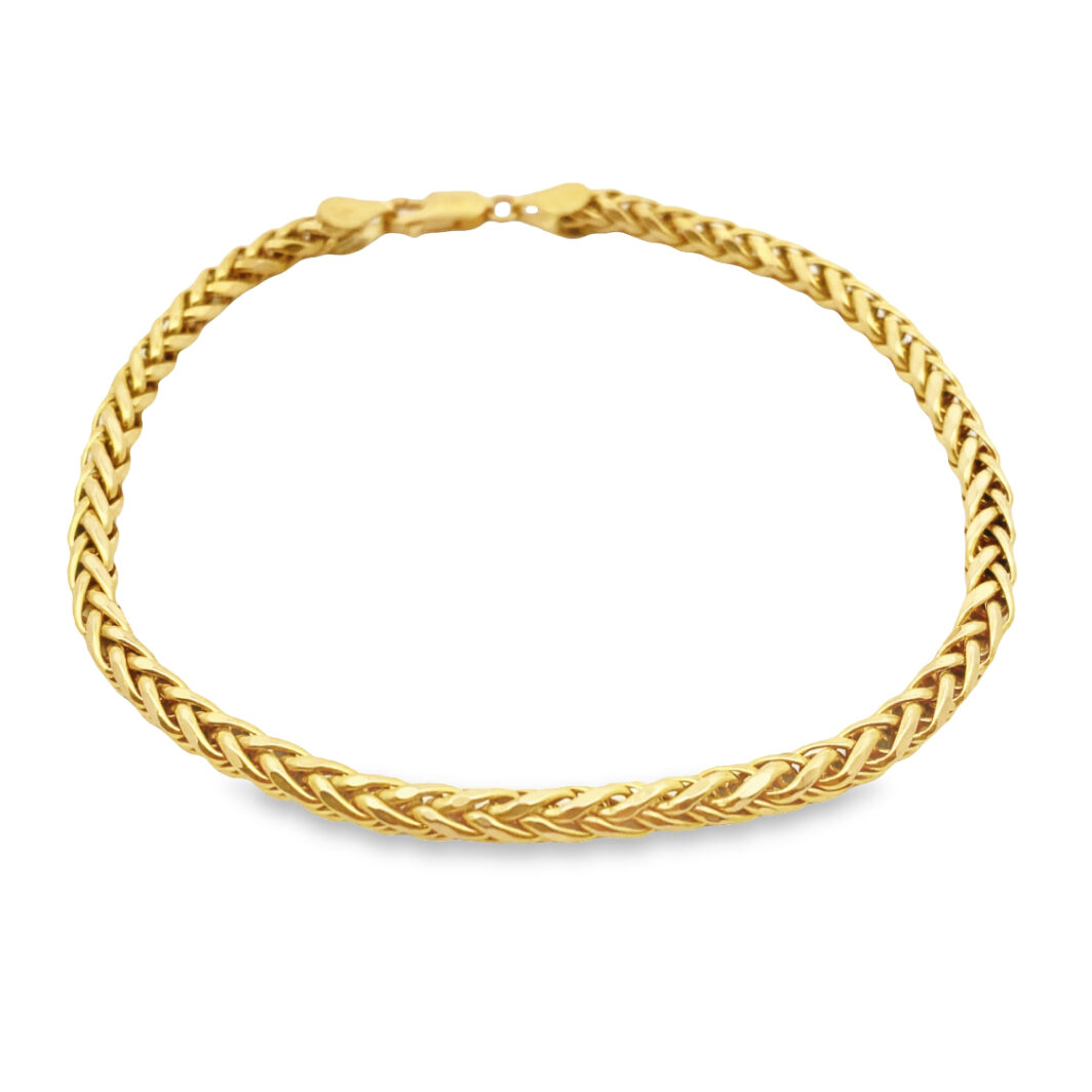 a gold bracelet with braiding on it
