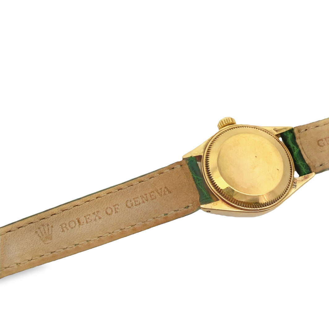 a gold watch with green leather straps on a white background