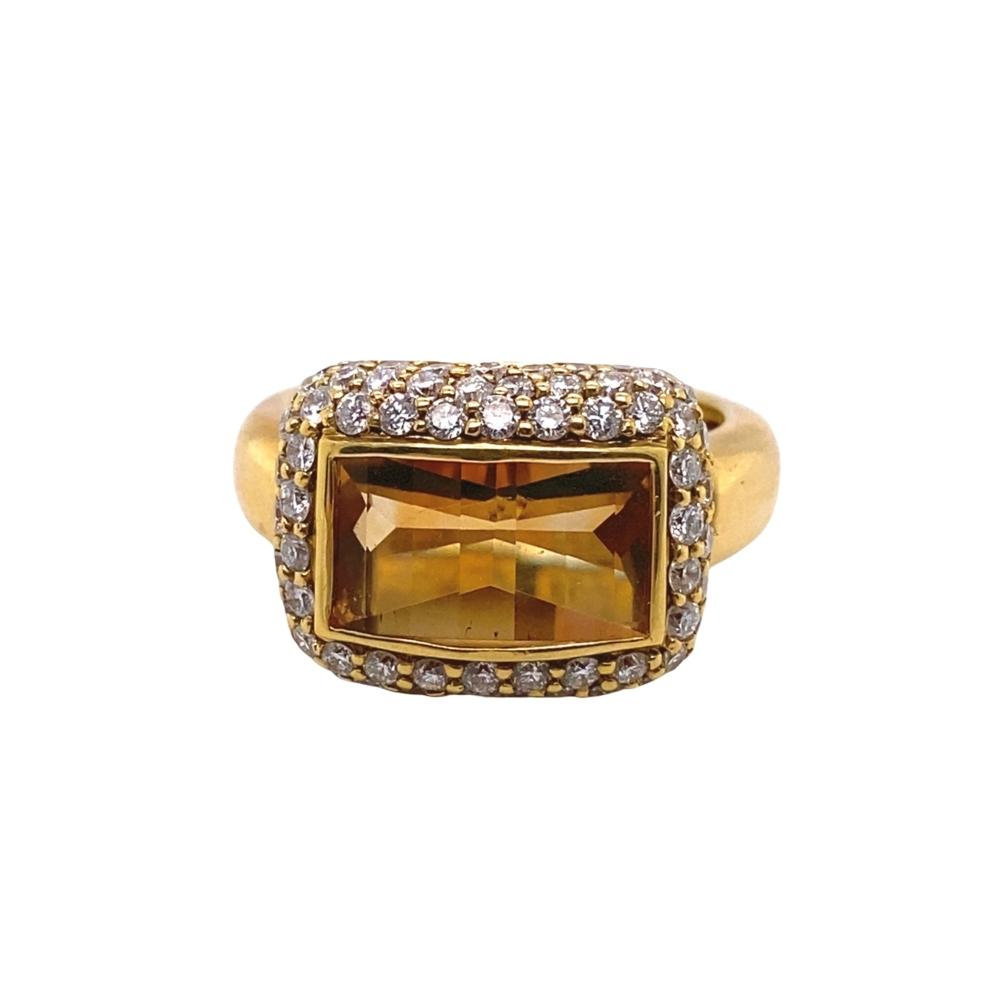 a gold ring with an orange stone surrounded by diamonds