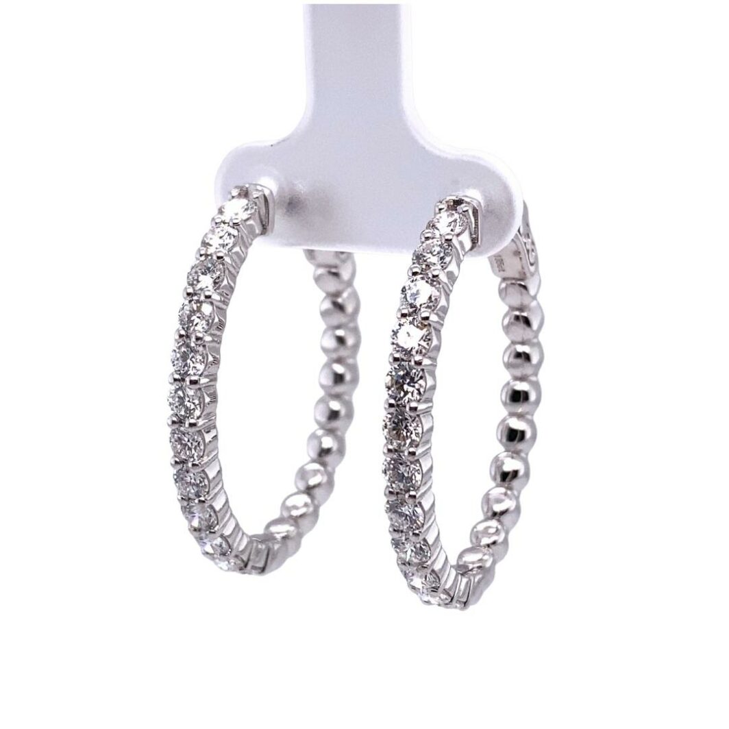 a pair of silver hoop earrings on a white background