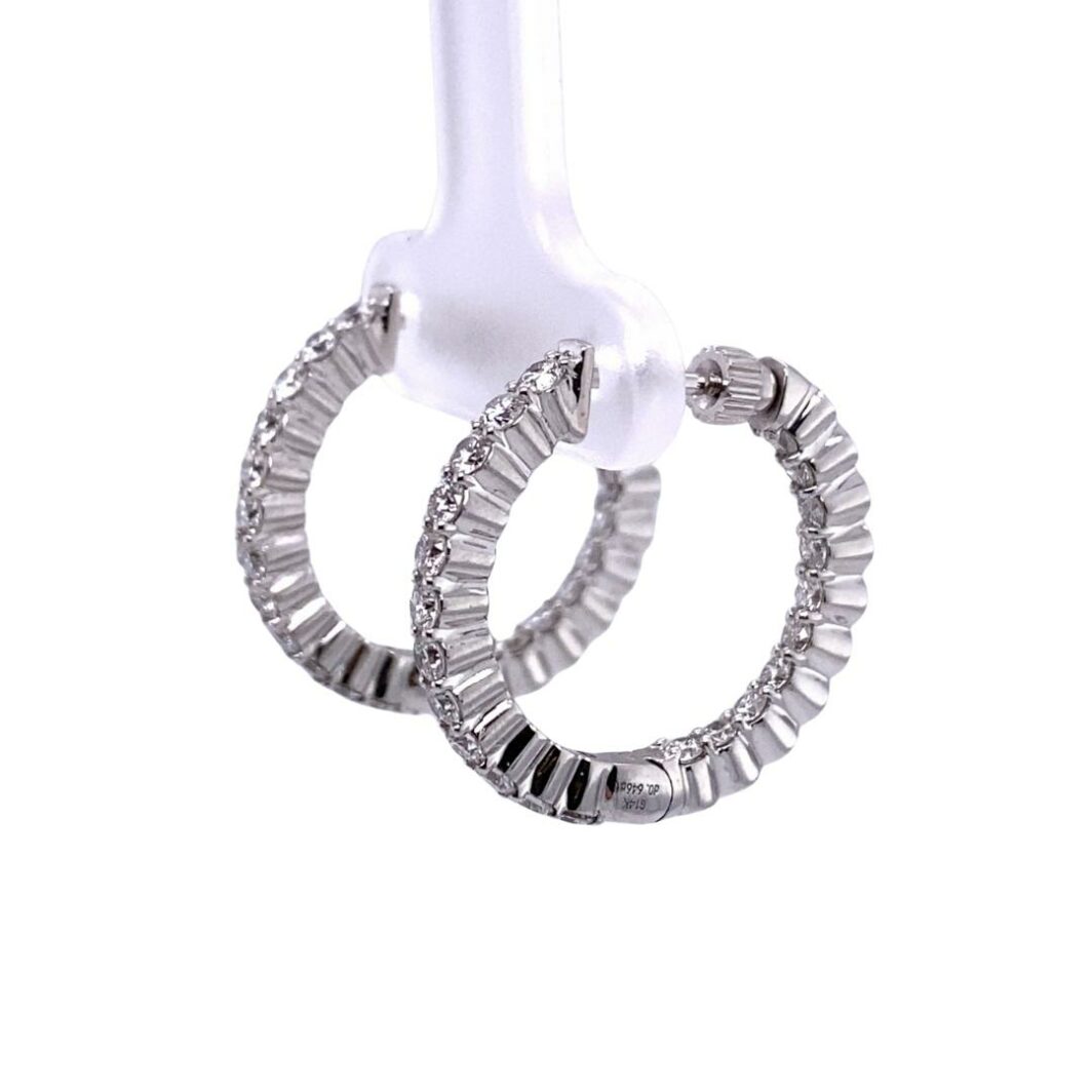 a pair of silver hoop earrings hanging from a hook
