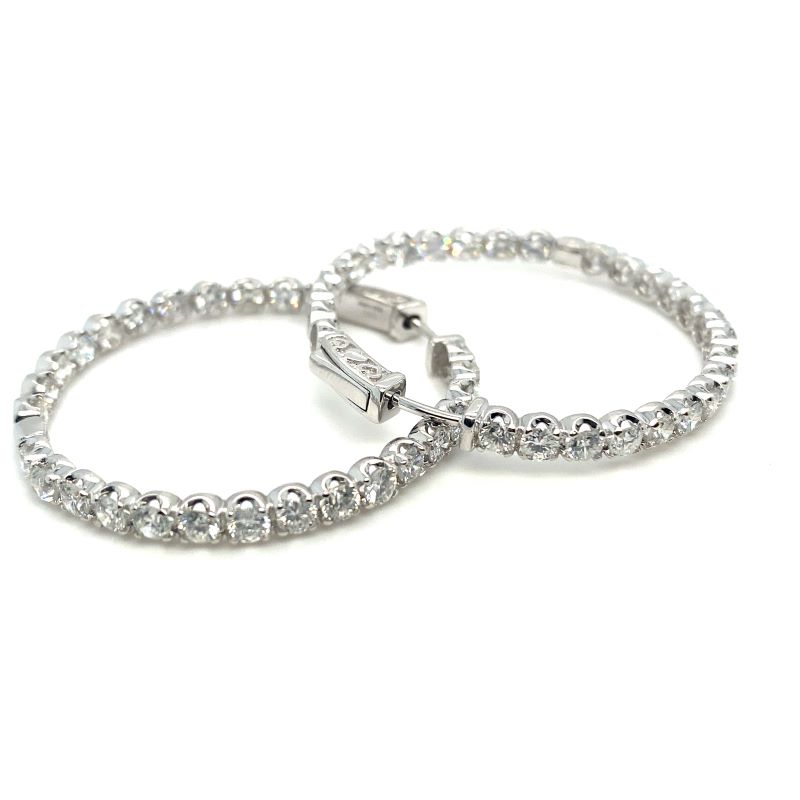 two silver bracelets with clear stones on them