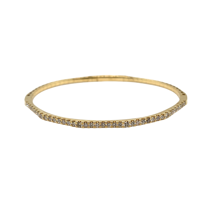 a thin yellow gold bang bracelet with diamonds