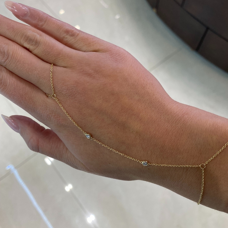 a woman's hand with a gold chain bracelet
