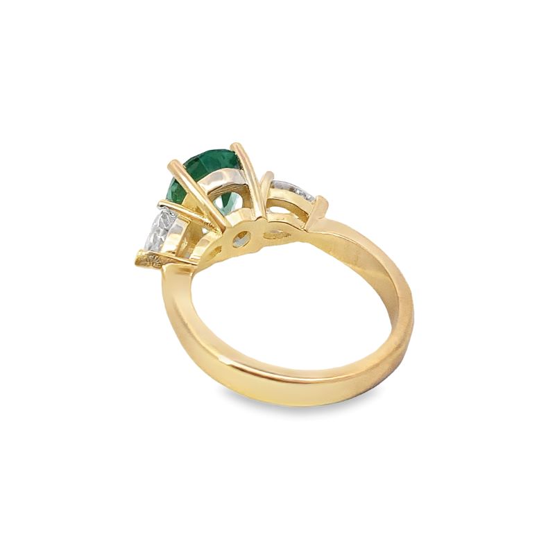 a yellow gold ring with two emeralds and three diamonds